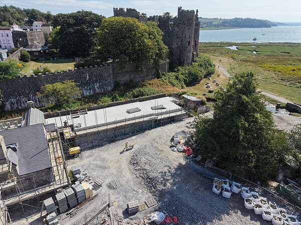 The castle curtain wall rising above the Island House site, seen from the castle side.