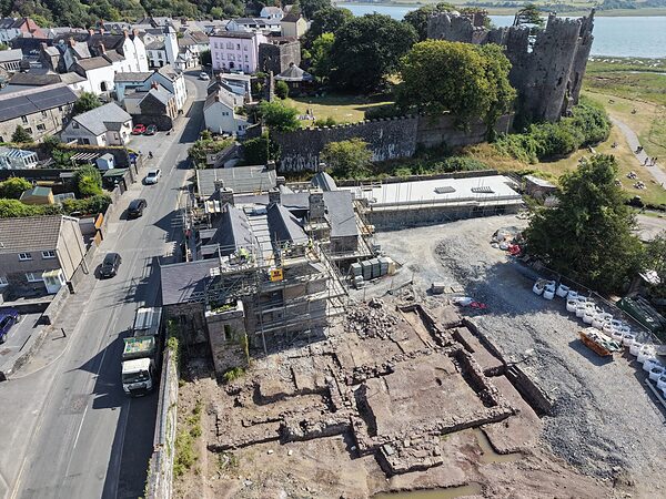 Island House, the excavation and Laugharne Castle from the air, with the town along Wogan Street and the Taf estuary beyond.