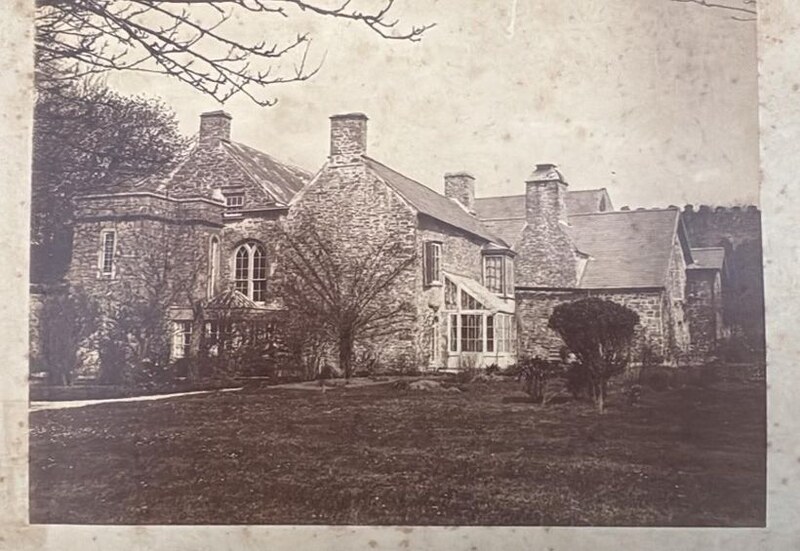 A Victorian photograph of the garden front of Island House: gabled ranges and tall chimneys above a lawn, with a conservatory against the wall.